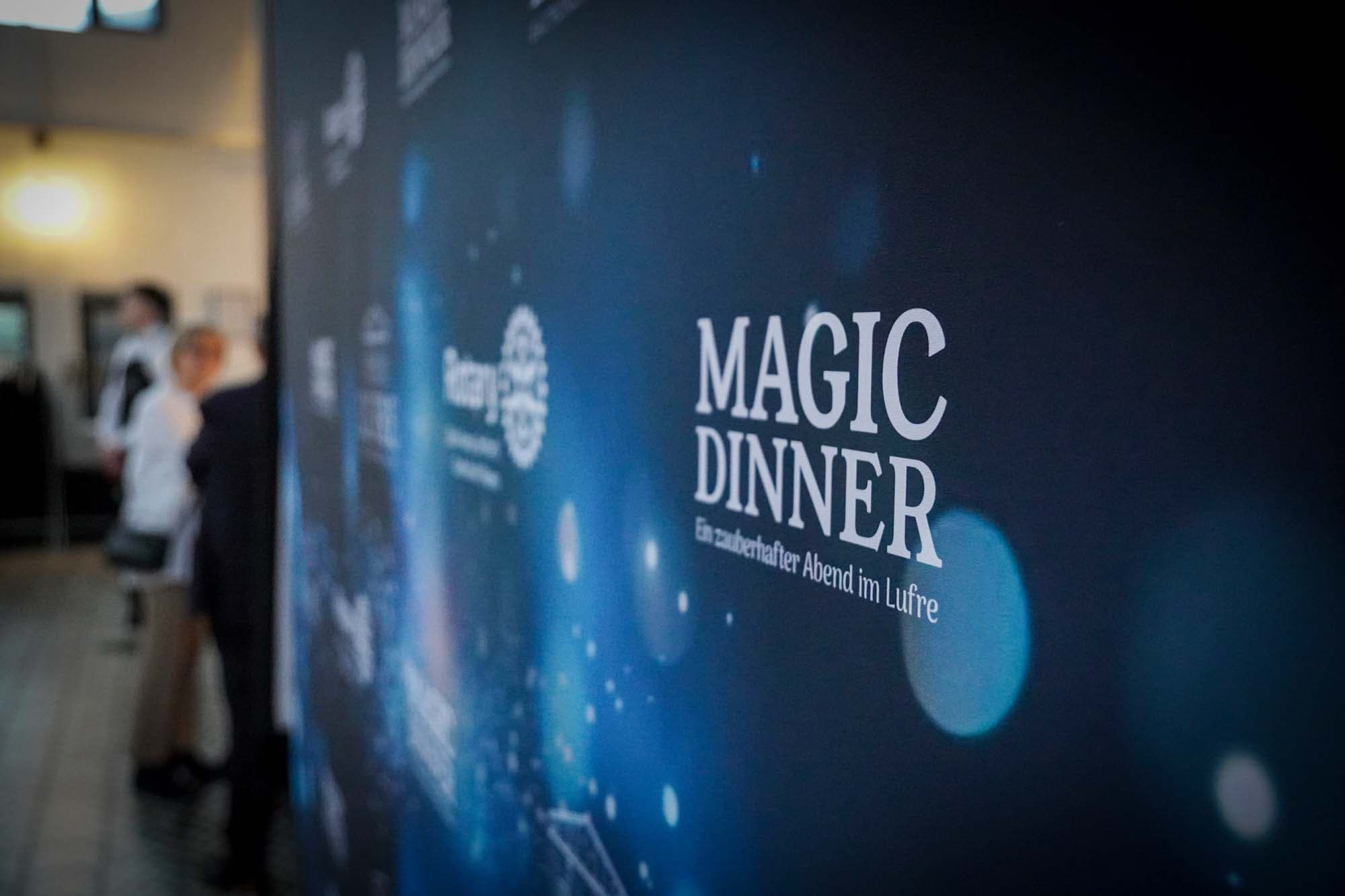 Nahaufnahme der dunkelblauen Fotowand mit dem Schriftzug Magic Dinner und Rotary-Logo.